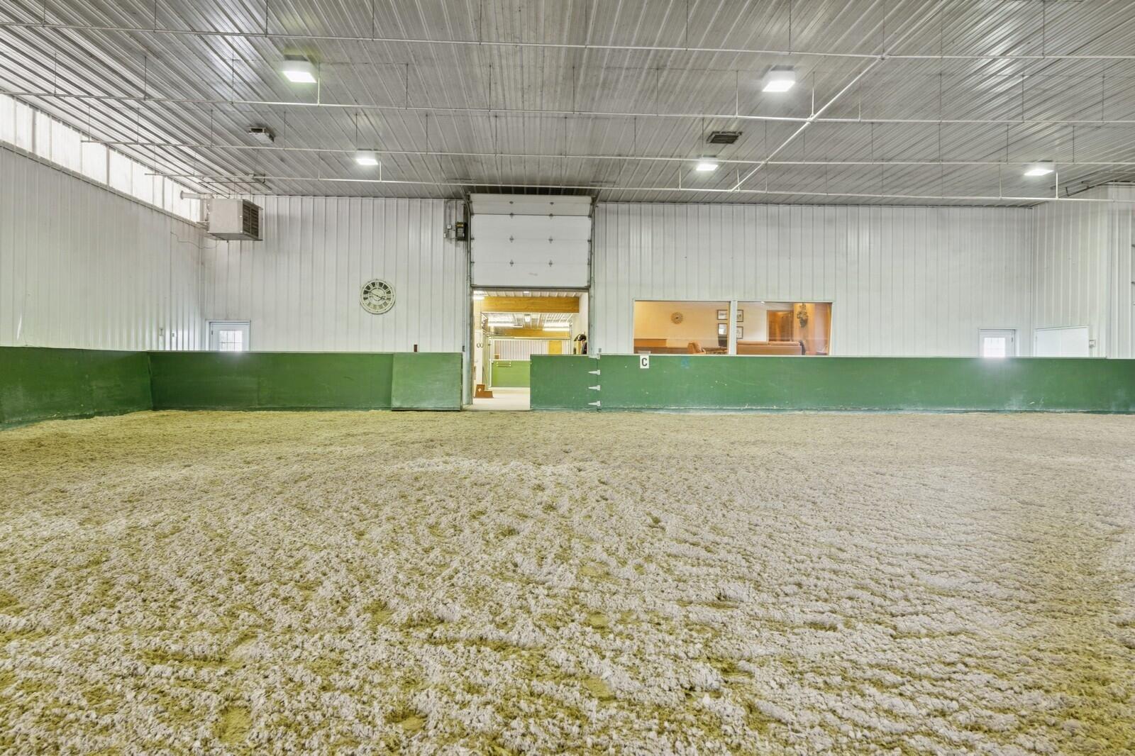 W1800 County Road B Bloomfield, WI 53128 - Photo 8 of 81 Additional perspective of the 80’ x 240’ single-span indoor arena showcasing the professionally maintained sand footing with GoldTex additive, full-span metal construction, perimeter kick walls, and overhead lighting designed for consistent, year-round riding conditions.