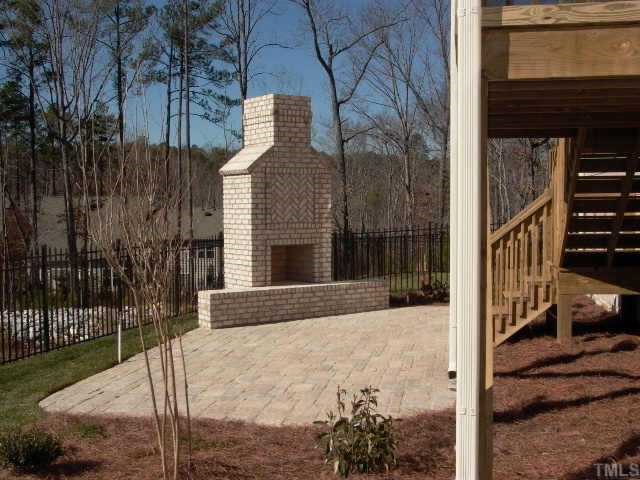 2204 Clayette Court Raleigh, NC 27612 - Photo 9 of 10 Great outdoor living space. Rear yard is fenced. Gas line for outdoor grill at edge of mortared stone patio. The brick outdoor fireplace has bench sitting. Entry to walk in storage is to the right. Full door on storage with poured concrete slab.