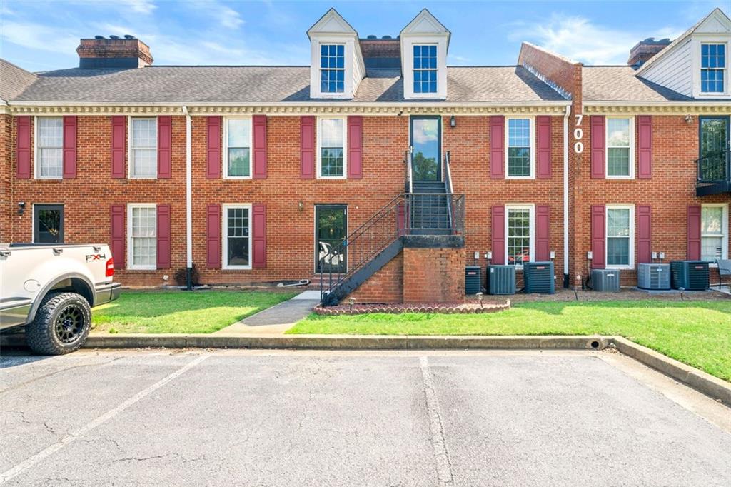 1166 Booth Road Southwest, Unit 706 Marietta, GA 30008 - Photo 1 of 1 a front view of a residential apartment building with a yard