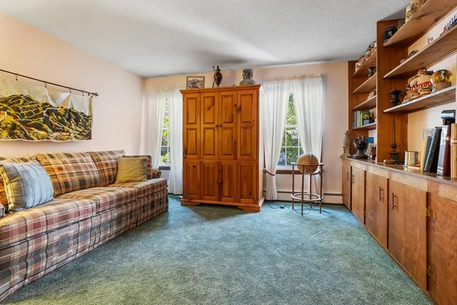 a living room with furniture and a refrigerator
