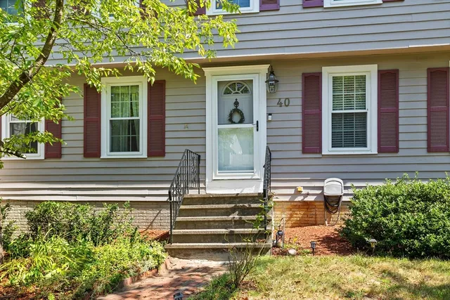 a front view of a house with a yard and trees