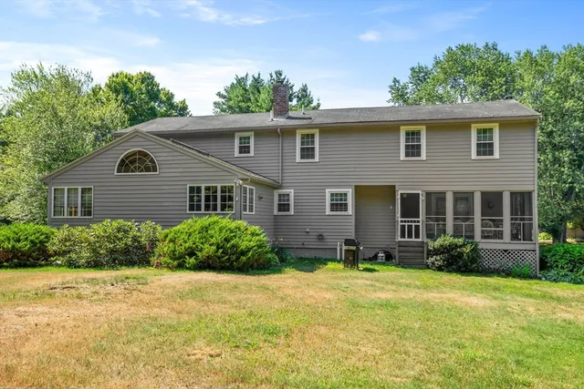 an aerial view of residential house with outdoor space and trees all around