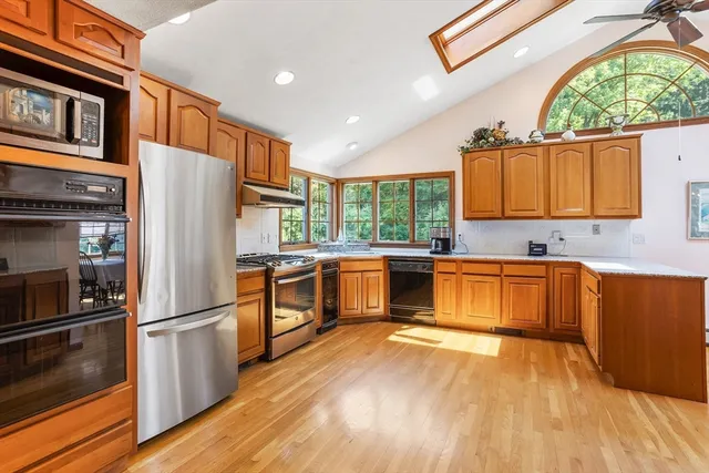 a kitchen with stainless steel appliances granite countertop a refrigerator a stove top oven and sink