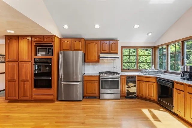 a kitchen with stainless steel appliances granite countertop a refrigerator a stove and a sink