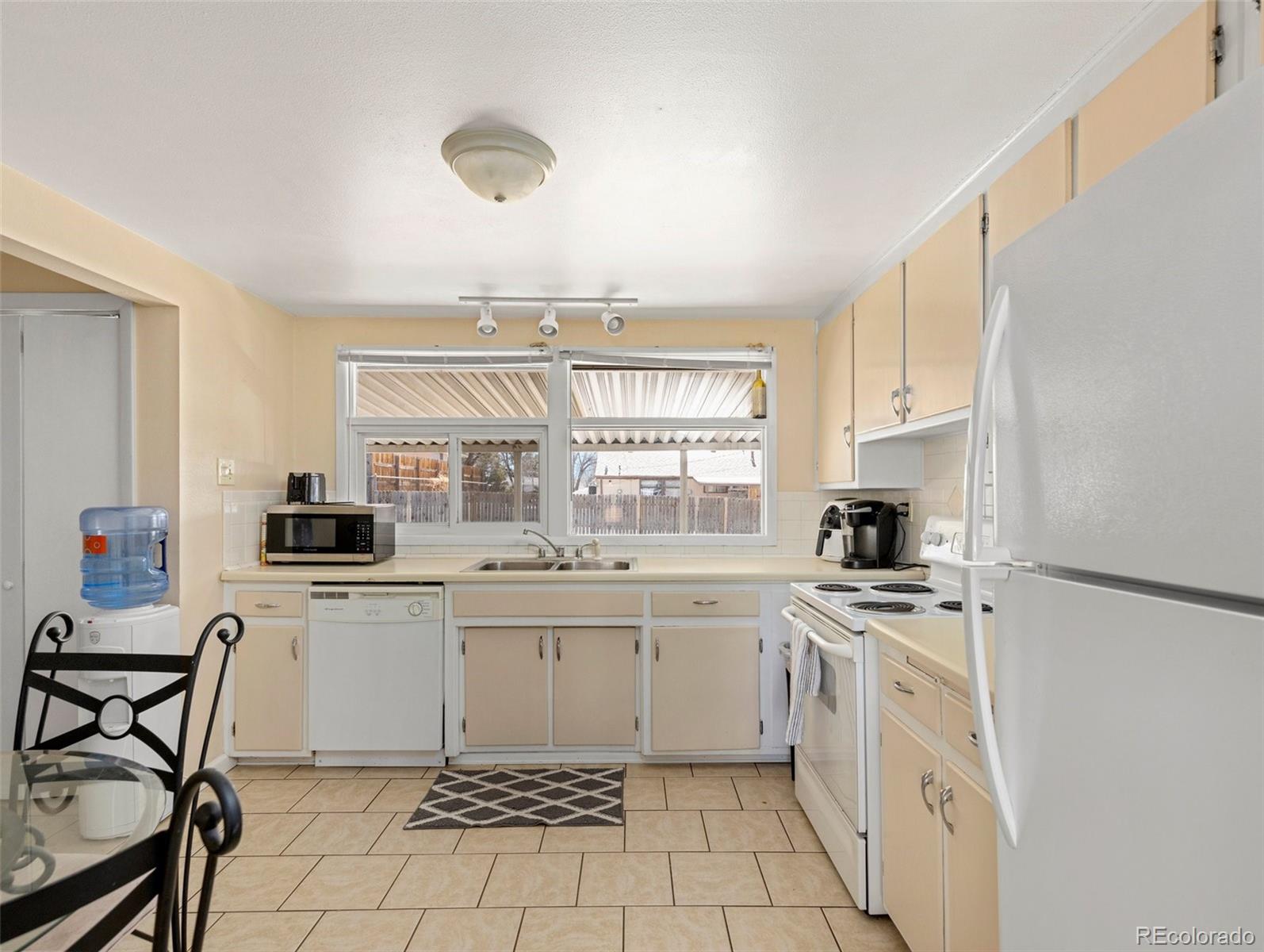 1802 Comanche Road Pueblo, CO 81001 - Photo 12 of 25 a kitchen with a stove a sink and a refrigerator