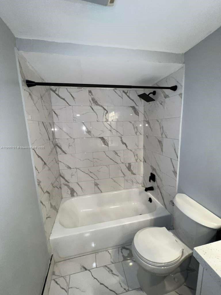 1799 Southwest 81st Terrace, Unit 135 Davie, FL 33324 - Photo 12 of 19 a white toilet sitting next to a bath tub and a shower