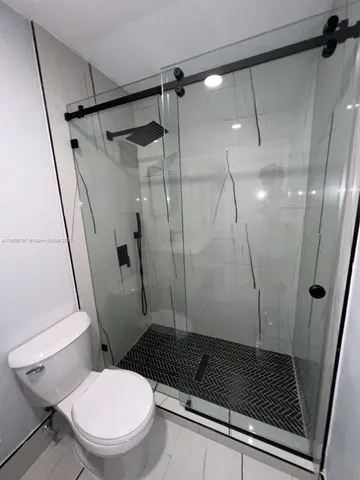 a bathroom with a toilet and a shower