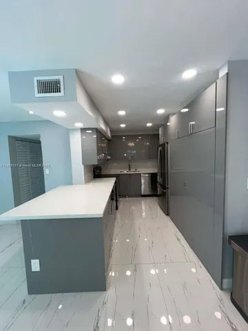 a open kitchen with a refrigerator a sink dishwasher and a large mirror