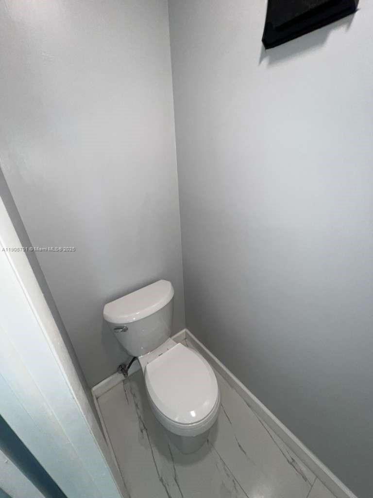 1799 Southwest 81st Terrace, Unit 135 Davie, FL 33324 - Photo 8 of 19 a white toilet sitting next to a white wall