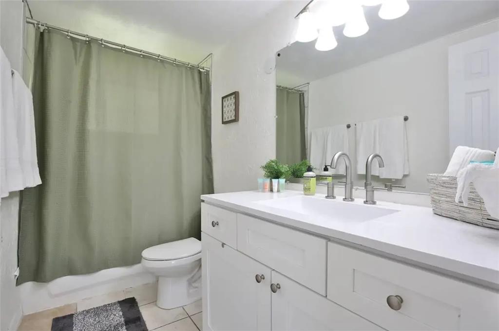 5622 South Lockwood Ridge Road Sarasota, FL 34231 - Photo 21 of 26 a bathroom with a sink a toilet and a mirror