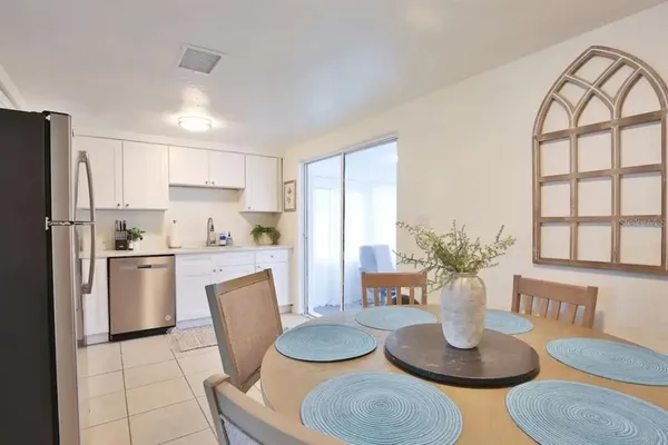 a kitchen with granite countertop stainless steel appliances a table and chairs in it