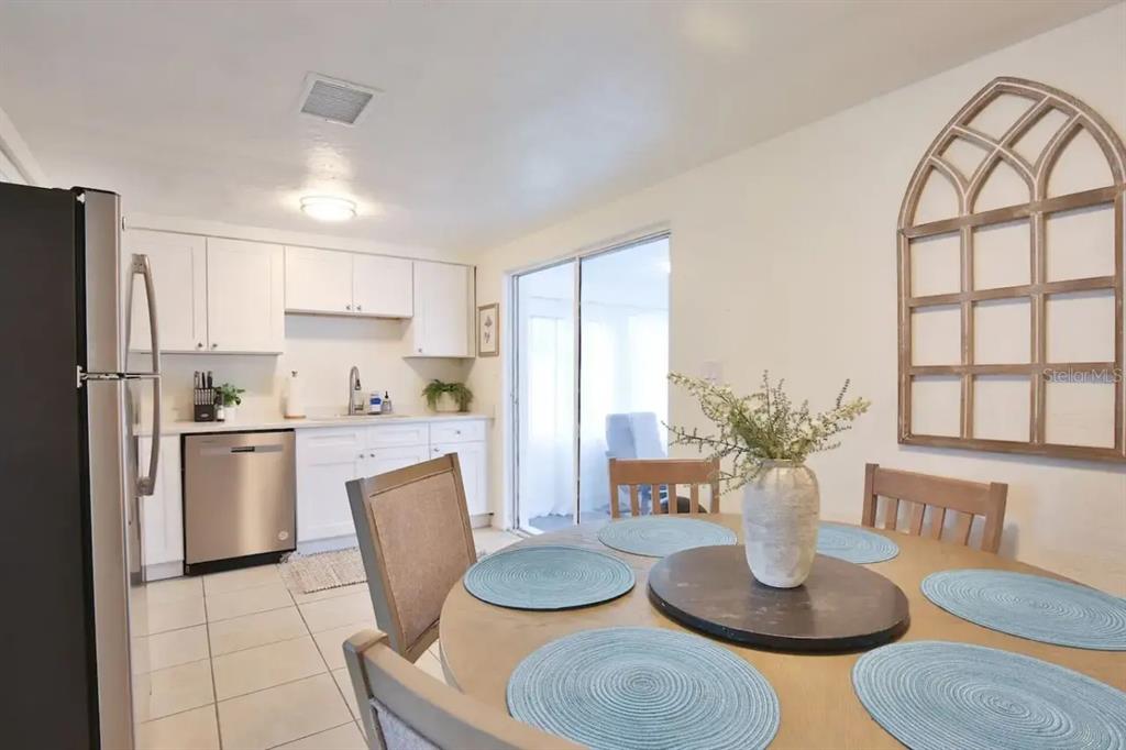 5622 South Lockwood Ridge Road Sarasota, FL 34231 - Photo 9 of 26 a kitchen with granite countertop stainless steel appliances a table and chairs in it