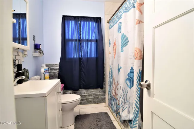 a bathroom with a sink a toilet and shower curtain