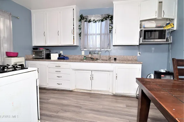 a kitchen with stainless steel appliances granite countertop a sink stove and cabinets