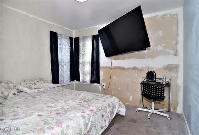 a bedroom with a bed and a television