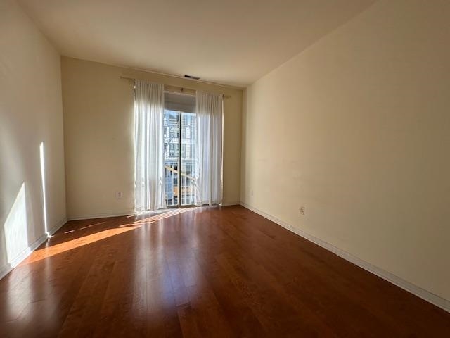 26 Ave At Port Imperial, Unit 210 West New York, NJ 07093 - Photo 5 of 10 an empty room with wooden floor and windows with curtains