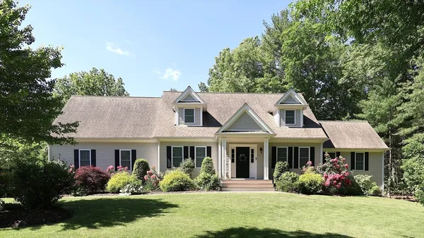 a front view of a house with a yard and potted plants