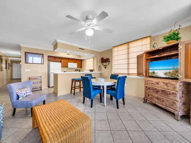 a living room with furniture a flat screen tv and kitchen view