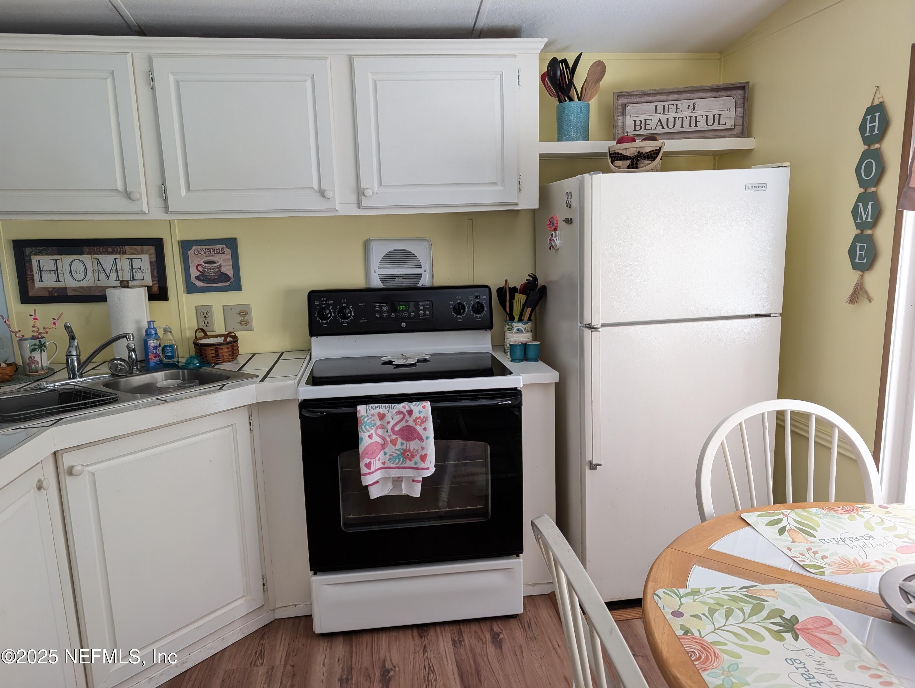 114 Ash Street Interlachen, FL 32148 - Photo 9 of 22 a kitchen with a appliances a sink and a refrigerator