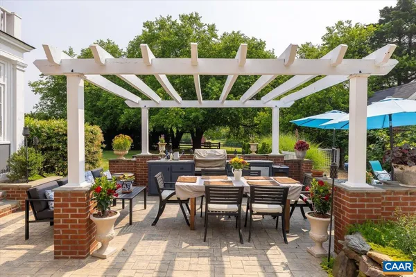 a kitchen with a stove a sink dishwasher a dining table and chairs with wooden floor