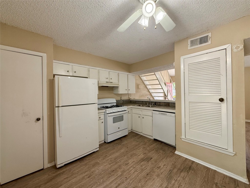 3448 Willowrun Drive, Unit C Austin, TX 78704 - Photo 3 of 9 a kitchen with appliances a refrigerator and a stove top oven