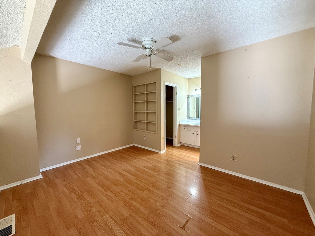 3448 Willowrun Drive, Unit C Austin, TX 78704 - Photo 6 of 9 a view of an empty room with wooden floor and a ceiling fan
