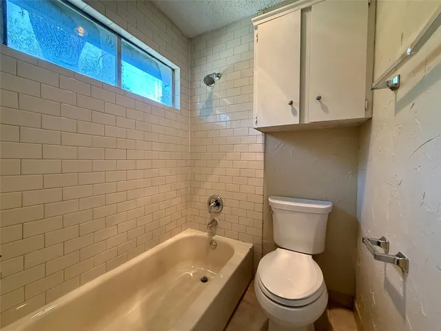 a white toilet sitting next to a bath tub
