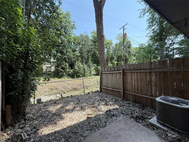 a view of a backyard with wooden fence and trees
