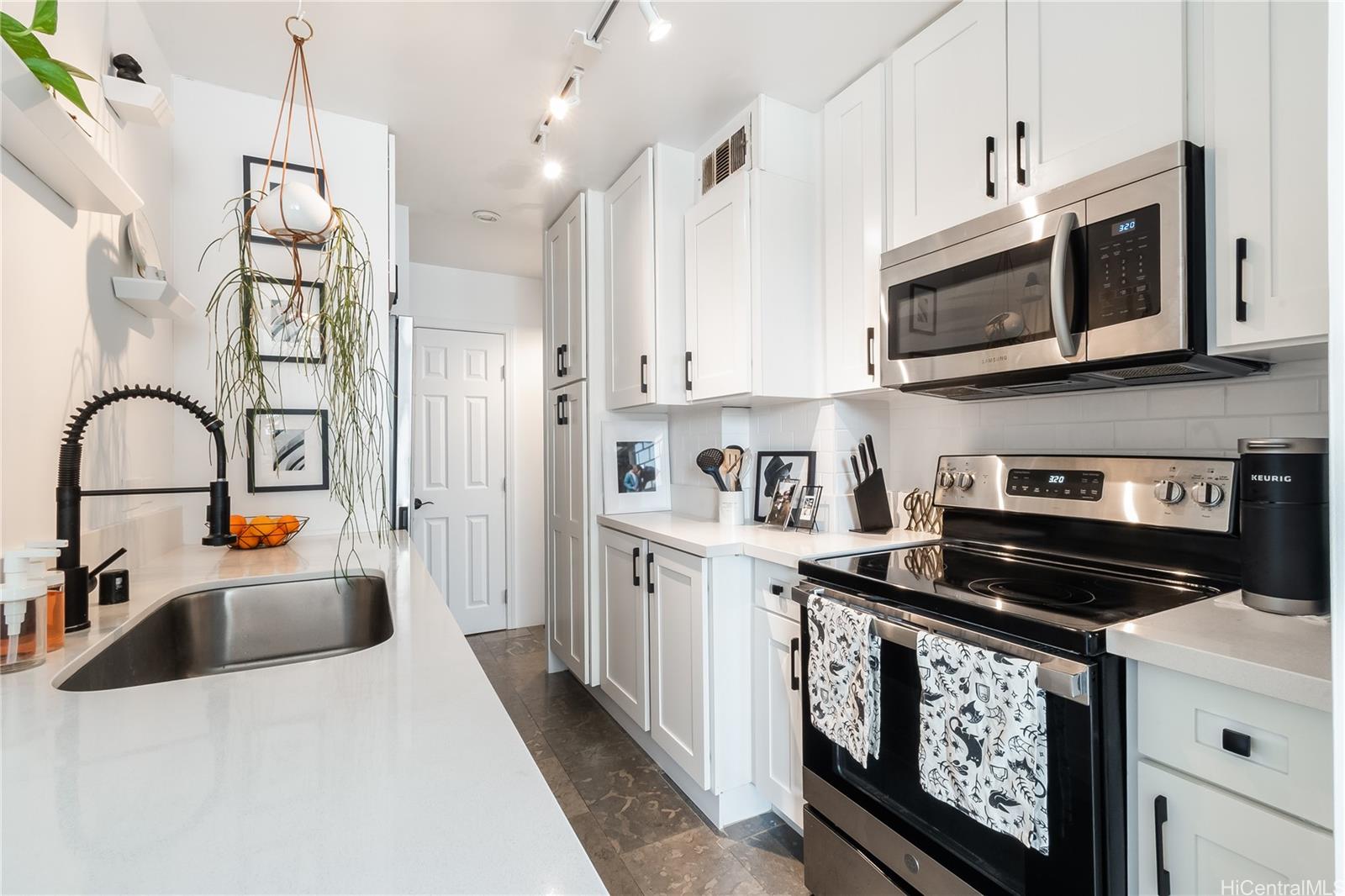 1069 Spencer Street, Unit 402 Honolulu, HI 96822 - Photo 1 of 15 a kitchen with stainless steel appliances granite countertop a stove a sink and a microwave