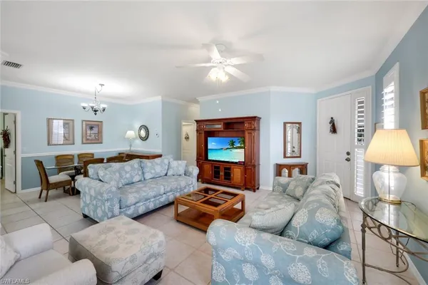 a living room with furniture a lamp and a flat screen tv