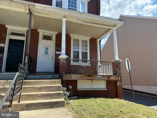 a view of a house with a small yard and wooden floor and fence
