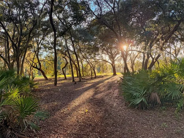 a kitchen with stainless steel appliances granite countertop a refrigerator a sink dishwasher a dining table and chairs with wooden floor