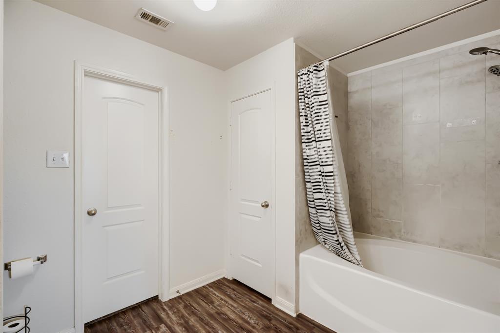4309 Cat Tail Way Forney, TX 75126 - Photo 20 of 30 Master bathroom with bathtub with a curved shower rod, large format wall tiling, and wood-finish flooring