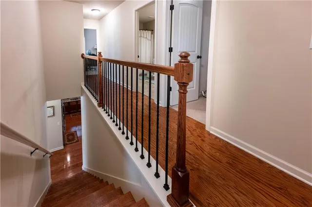 a view of a hallway with wooden floor and staircase