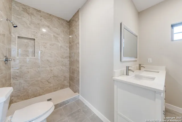 a bathroom with a sink a toilet and shower