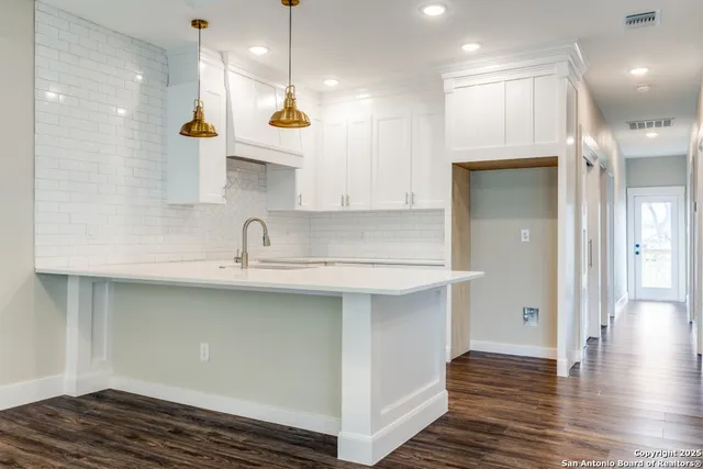 a view of a kitchen with a sink and wooden floor