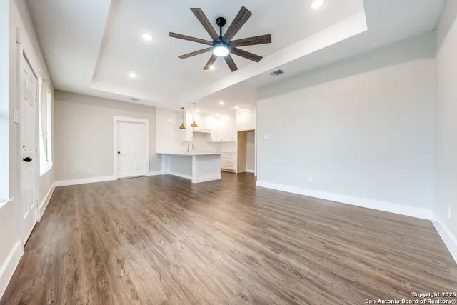 a view of empty room with wooden floor and a ceiling fan