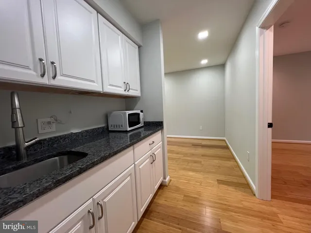 a kitchen with granite countertop a sink and cabinets