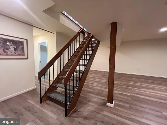 a view of staircase with wooden floor and white walls