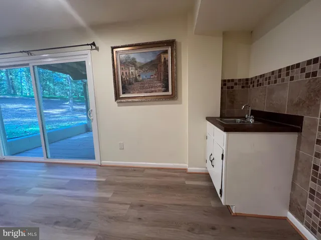 a view of a furniture and an empty room with wooden floor