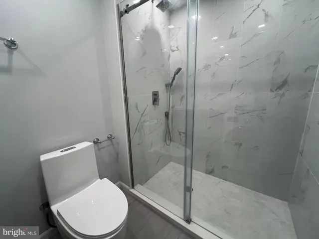 a white toilet next to a bathroom