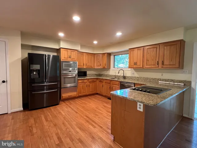a kitchen with stainless steel appliances granite countertop a stove refrigerator and a sink