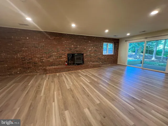 a view of empty room with wooden floor and fireplace