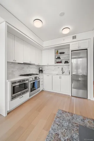 a kitchen with a refrigerator and a stove top oven