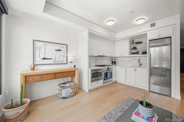 a kitchen with a refrigerator sink and cabinets