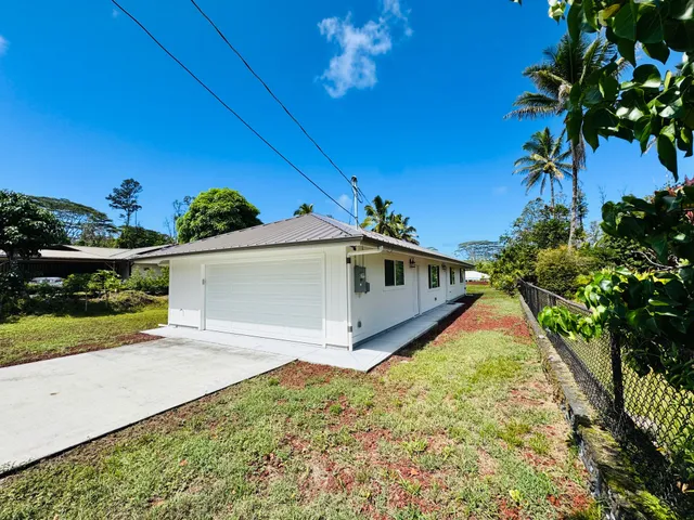 a view of a white house with a yard