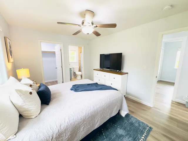 a bedroom with a bed and wooden floor