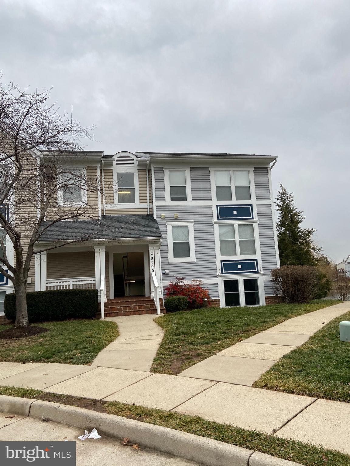 20590 Cornstalk Terrace, Unit 302 Ashburn, VA 20147 - Photo 1 of 38 a front view of a house with a yard and garage