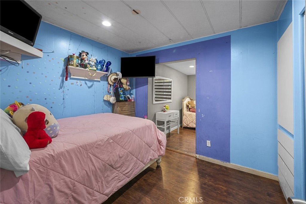 3255 East Avenue R, Unit 34 Palmdale, CA 93550 - Photo 13 of 32 a bed room with a bed and a tv