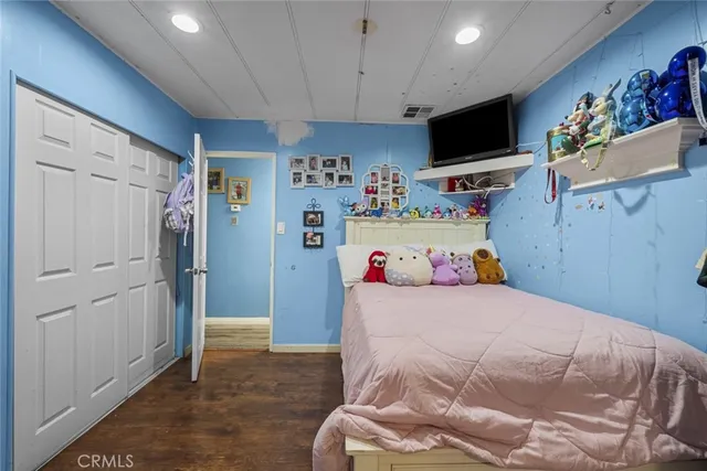 a bedroom with a bed and flat screen tv